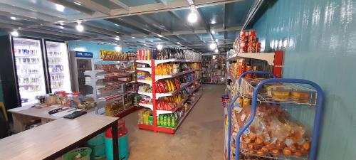 a store aisle of a grocery store with food and drinks at Wind Valley Farmstay in Kundasang