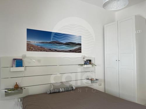ein Schlafzimmer mit einem Bett und einem Gemälde an der Wand in der Unterkunft Villetta Carmine By Cala Salento in Torre Lapillo