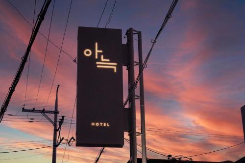 a sign on a pole in front of a sunset at Aank Hotel Osan in Osan