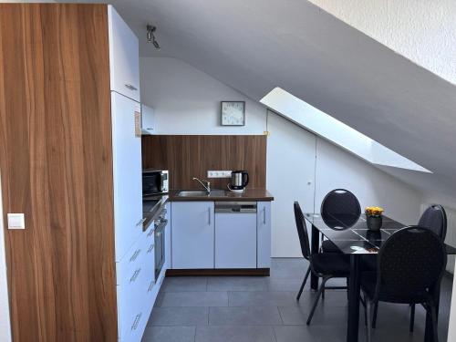 een keuken en eetkamer met een tafel en stoelen bij Burghotel Lörrach in Lörrach