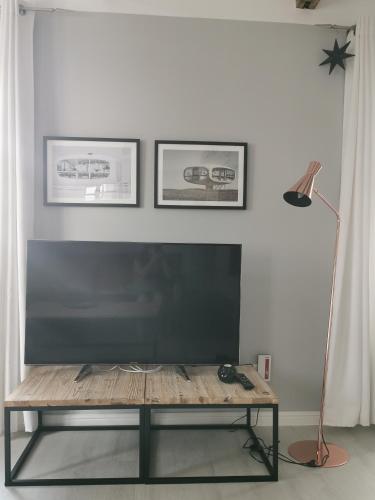 a living room with a flat screen tv and a table at Homelig Altstadt Ferienwohnungen Sassnitz in Sassnitz