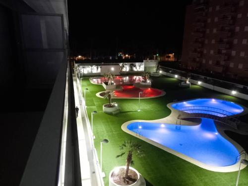 - une vue sur la piscine du bâtiment la nuit dans l'établissement Tropical y Lujoso Complejo, à Oropesa del Mar