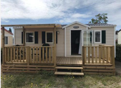 une petite maison avec une grande terrasse en bois dans l'établissement Mobilhome 6 places, à Vic-la-Gardiole