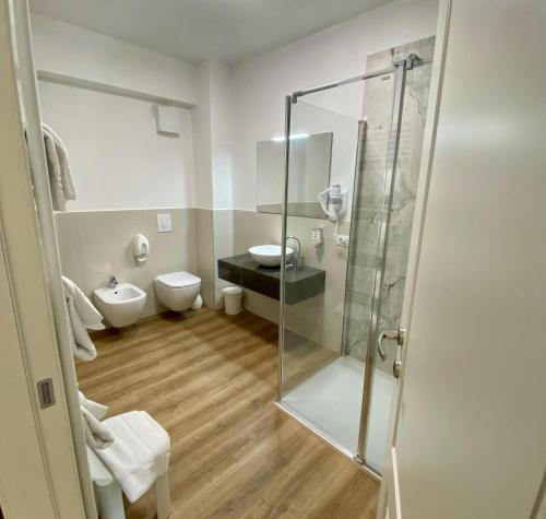 a bathroom with a glass shower and a toilet at Hotel Pai in Torri del Benaco