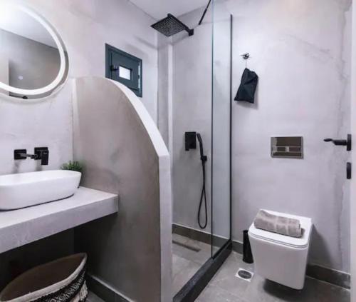 uma casa de banho com um lavatório, um chuveiro e um WC. em Havana 5 studio Sea and Pool em Gázion
