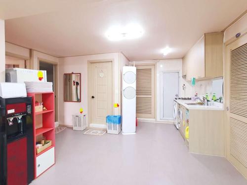 a kitchen with a refrigerator and a sink at Happy Garden Guesthouse in Seoul