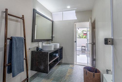 La salle de bains est pourvue d'un lavabo et d'un miroir. dans l'établissement BALANCE BEACH VILLA, à Koh Samui 