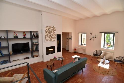 a living room with a couch and a tv at L'Atelier Appartement au cœur du vignoble in Rognes