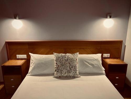 a bedroom with a bed with two night stands and two lamps at Casa Rural A Bouciña in Hio