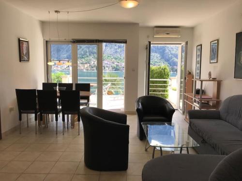 a living room with a couch and a table and chairs at Two bedroom Apartment in Kotor Bay in Muo