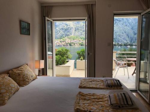 a bedroom with a bed with a view of the water at Two bedroom Apartment in Kotor Bay in Muo