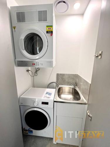 a small kitchen with a sink and a washing machine at Fab in Phillip - 2bd 2bth Apt - Close to CBR Hospital in Phillip