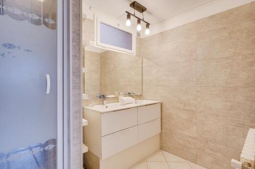 La salle de bains est pourvue d'un lavabo et d'un miroir. dans l'établissement La Casa Bohème - Superbe maison avec parking privé, à Bordeaux