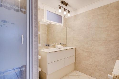 łazienka z umywalką i lustrem w obiekcie La Casa Bohème - Superbe maison avec parking privé w mieście Bordeaux