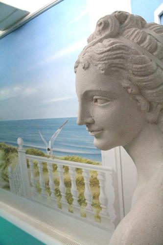 a statue of a woman on a balcony with the ocean at Parkhotel Fischer in Wernigerode