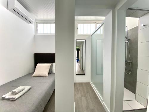 Dormitorio pequeño con cama y ducha en New Garden Solarium Bungalow, en Maspalomas