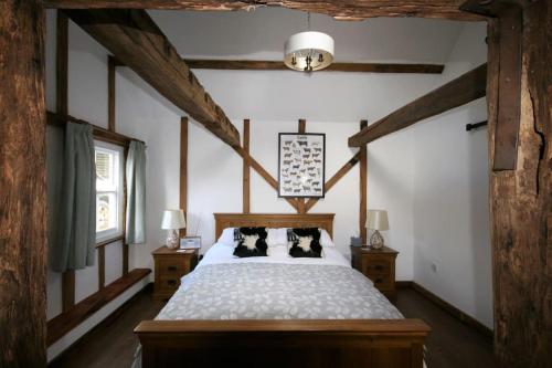 una camera con un letto con due cuscini sopra di The Calf Shed at Broxhall Farm a Canterbury