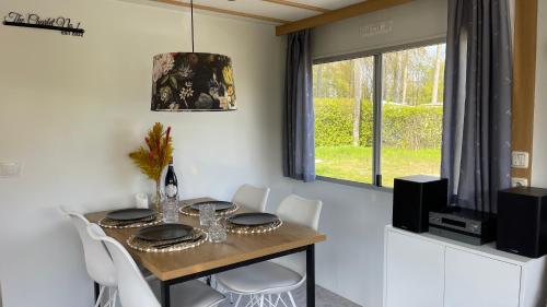 a dining room with a table and white chairs at PURE - Chalet Zeeland - garden out of sight in Hoek