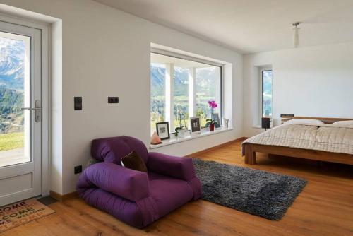 Un dormitorio con una silla púrpura y una cama en Panorama Chalet Fastenberg, en Schladming