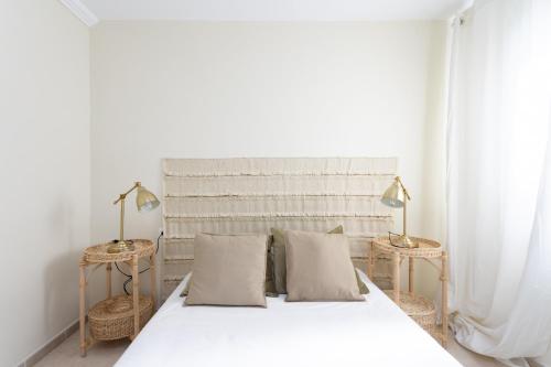 una camera da letto con un letto bianco con due tavoli e due lampade di EDEN RENTALS Ocean Poris Pearl a Poris de Abona