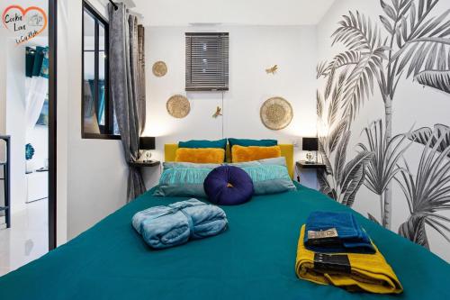 - une chambre avec un lit vert et des oreillers bleus dans l'établissement Cookie Love - entièrement neuf - à 100 m de l'entrée du village naturiste, au Cap d'Agde