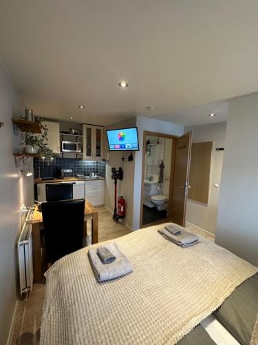 a room with a bed and a kitchen with a tv at Norðurgata 43 in Akureyri
