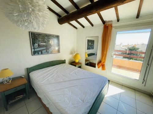 um quarto com uma cama e uma grande janela em Appartement Cap d'Agde, 4 pièces, 8 personnes - FR-1-723-27 em Bizanos