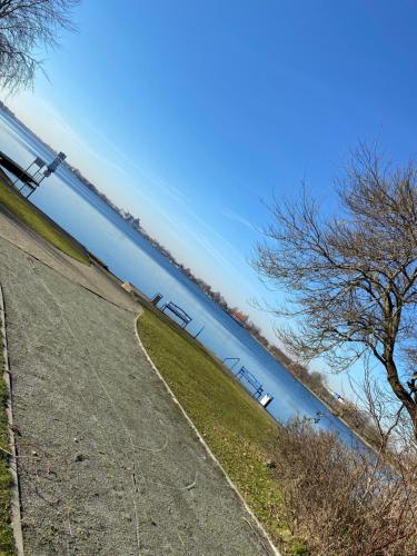 a train is going down a hill next to the water at FeWo an der Nordseeküste I in Wilhelmshaven