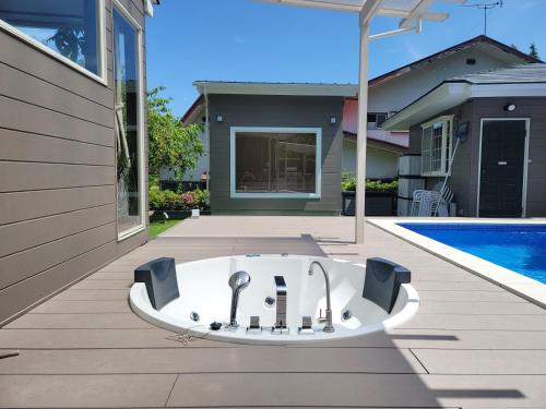eine Badewanne auf einer Terrasse neben einem Pool in der Unterkunft フレッチア in Futo