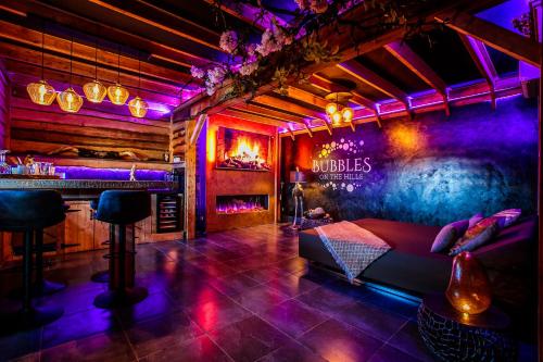 a room with a bed and a bar with purple lights at Bubbles on The hills in Groesbeek