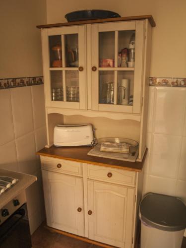 a kitchen with white cabinets and a toaster at Casa Mallos de Agüero in Agüero