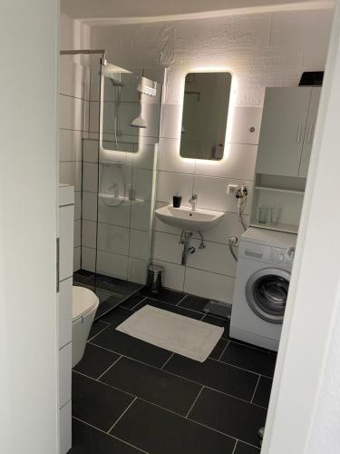 a bathroom with a sink and a washing machine at FeWo an der Nordseeküste mit Garage in Wilhelmshaven