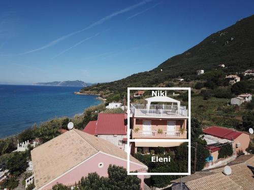 an aerial view of a house on a hill next to the water at NIKI in Paramonas