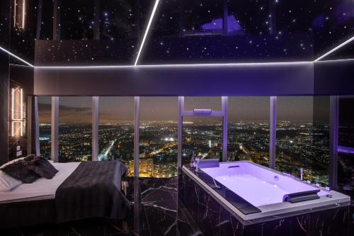 a room with a bed and a bath tub at In The Sky - Apartamenty w Sky Tower in Wrocław