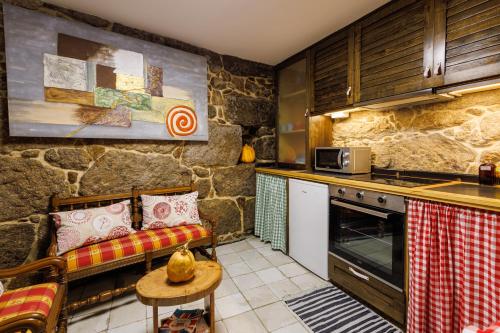 a kitchen with a couch and a table in a room at A de Calón in Marín