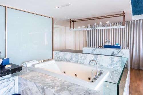 y baño con bañera con pared de cristal. en A-One The Royal Cruise Hotel Pattaya - SHA Extra Plus en Pattaya centro