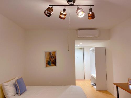 1 dormitorio con 1 cama y luces en el techo en Nakijin Resort Guest House, en Nakijin
