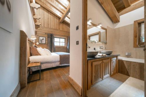 a bathroom with two sinks and a bed in a room at Le Chalet des Ours in Megève