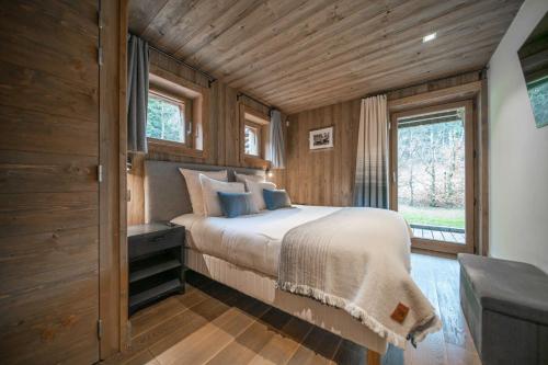 a bedroom with a bed in a wooden cabin at Le Chalet des Ours in Megève