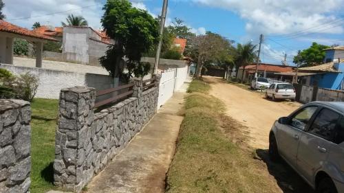 a street in a village with a stone wall at Casa sonho sonhado in São Pedro da Aldeia