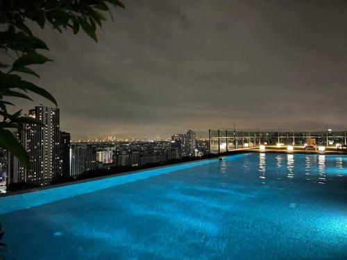 a large swimming pool with a city skyline at night at HIGH RISE LUXURY CONDO 1BED ROOF TOP POOL 2 MinMRT in Bangkok