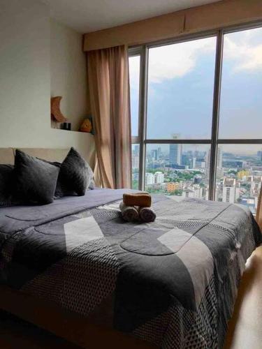 a bedroom with a bed and a large window at HIGH RISE LUXURY CONDO 1BED ROOF TOP POOL 2 MinMRT in Bangkok