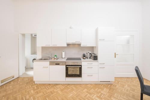 uma cozinha com armários brancos e um forno com placa de fogão em Anna and Friends em Graz