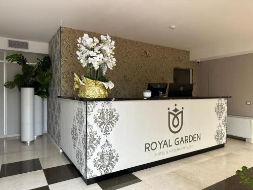 パドヴァにあるRoyal Garden luxury roomsのロビーには花の入ったフロントカウンターがあります。