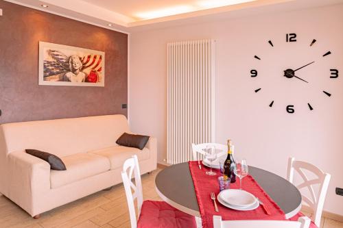 a living room with a table and a clock on the wall at BELLA VITA Residence in Gravedona