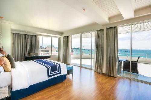 a bedroom with a bed and a view of the ocean at A-One The Royal Cruise Hotel Pattaya - SHA Extra Plus in Pattaya
