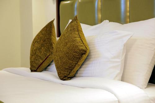 two pillows sitting on a bed with white pillows at Hotel Cama in Chandīgarh