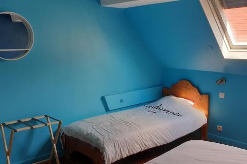 - une chambre dotée d'un mur bleu et d'un lit dans l'établissement The Cat ,maison de vacances à 50m de la plage, à Le Portel