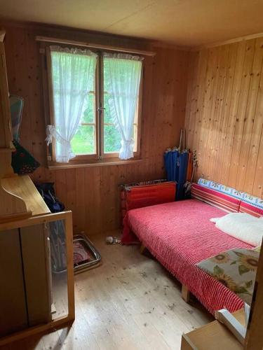 a small room with a bed and a window at Behagliches Chalet mit Kaminofen umgeben von Natur in Glarus