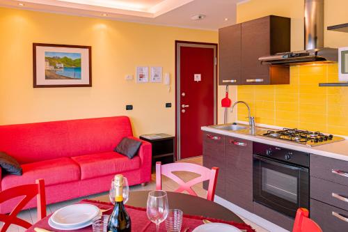 a kitchen and a living room with a red couch at BELLA VITA Residence in Gravedona